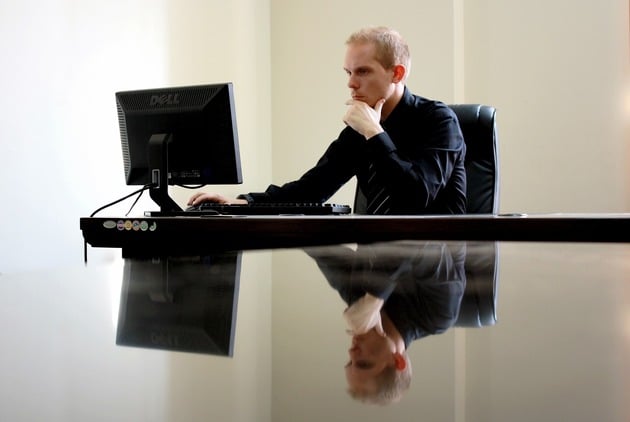 uomo che lavora al pc seduto alla scrivania
